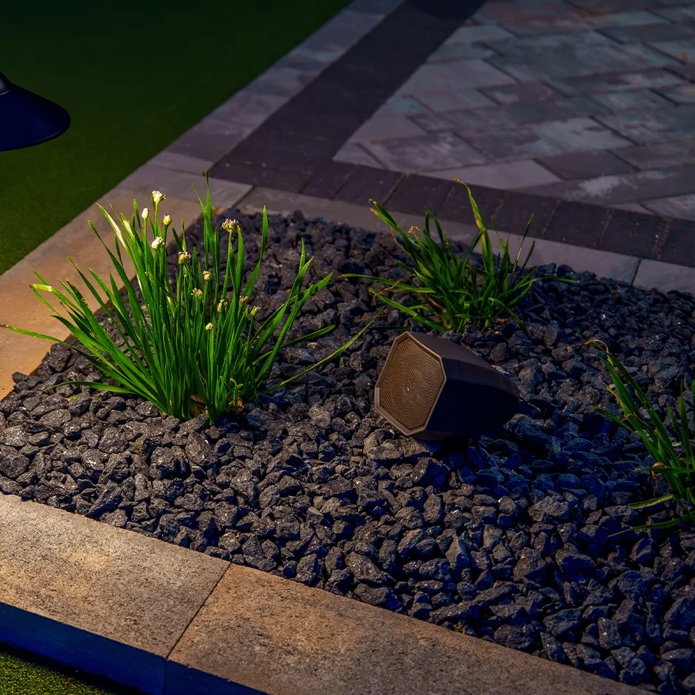 Landscape speaker discreetly placed in a garden bed